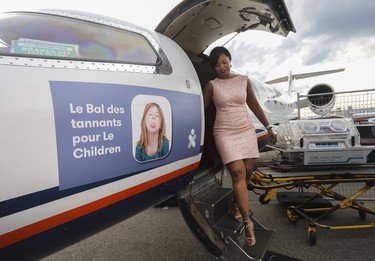 Roxanne Mirjah of Trans-Pro Logistics exits an air ambulance that was on display at the Bal des Tannants for the Children's in the Dorval area of Montreal on Friday, May 12, 2023. The event, in which guests were invited to show up with childish accents in their dress as a way to let their 'inner brats' show, was put on by the Montreal Children's Hospital Foundation and held in Starlink Aviation's hangar.