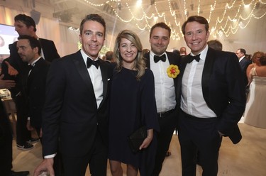 Mélanie Joly, federal Minister of Foreign Affairs, with her partner Félix Marzell (third from left) and former Liberal cabinet minister Scott Brison (with BMO) and his partner Maxime St-Pierre (left), at the Bal des Tannants for the Children's in the Dorval area of Montreal on Friday, May 12, 2023. The event, in which guests were invited to show up with childish accents in their dress as a way to let their 'inner brats' show, was put on by the Montreal Children's Hospital Foundation and held in Starlink Aviation's hangar.