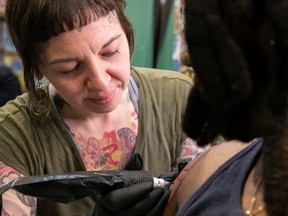 Tattoo artist Erika Doyon works the arm of Ma'Bui Riddim at her Verdun salon, Studio Artease.