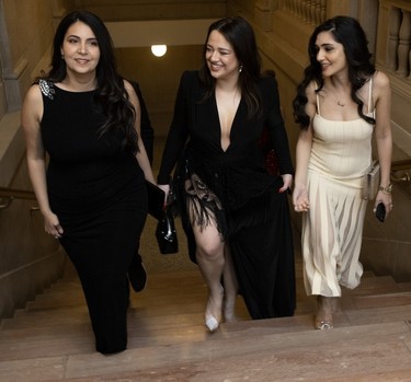 Three women walking up a staircase at a party
