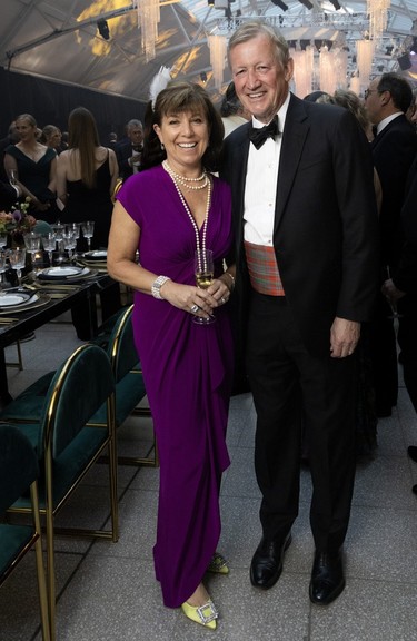 A woman in a purple dress and a man in a tuxedo at a ball