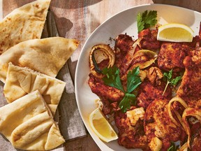 plated sumac chicken next to quartered pita