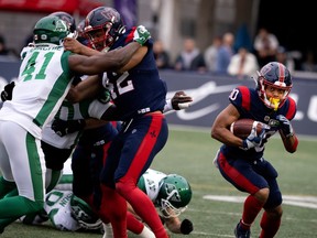 Tyrell Richards holds back a Roughriders player during a CFL game