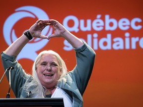 Manon Masse making a heart with her hands against a red QS background