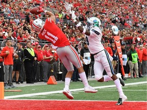 Austin Mack catches a football above his head in the end zone