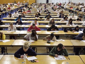 Students write exams in a large room