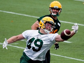 Fullback James Tuck attempts to make a catch in front of teammate Jordan Hoover during a practice in Edmonton in 2021. The Alouettes expect Tuck to play a large role in their backfield this season.