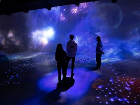 People standing and looking at an immersive experience