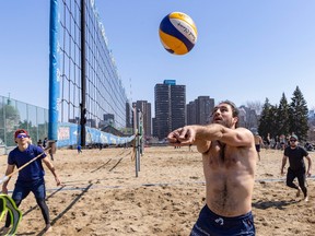 a man volleys during a beach volleyball game in montreal