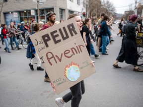 Wide view of a protest march with a cardboard sign reading "J'ai peur pour l'avenir"