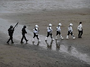 Stormtrooper cosplayers enjoy a stroll despite the weather in England in April.
