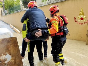 This photo provided by the Italian Firefighters shows firefighters rescuing a person from a flooded house in Riccione, in the northern Italian region of Emilia Romagna, Tuesday, May 16, 2023. Unusually heavy rains have caused major flooding in Emilia Romagna, where trains were stopped and schools were closed in many towns while people were asked to leave the ground floors of their homes and to avoid going out.