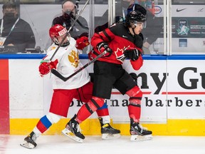 Canada's Donovan Sebrango, right, checks Russia's Matvei Michkov.