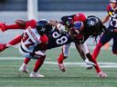 Montreal Alouettes wide receiver Kevin Kaya (88) is tackled by Ottawa Redblacks defensive back Brandin Dandridge (37) and defensive back Abdul Kanneh (14) during first half CFL pre-season football action in Ottawa on Friday, May 26, 2023.