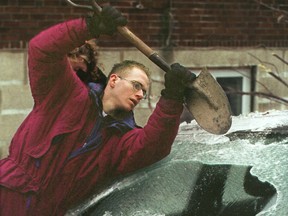 John Abcarius cleans his car windshield with spade shovel on Lincoln St. on Jan. 6, 1998, at the beginning of the ice storm.
