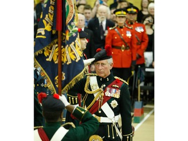Prince Charles salutes the new colours of the Black Watch in Montreal in 2009.