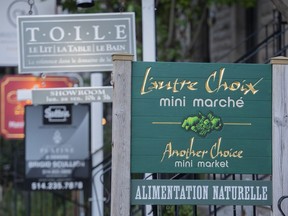 A bilingual sign for a mini-market is shown in Westmount on Aug. 5, 2022. All the municipalities in Quebec that were at risk of losing their bilingual status under a provincial language law have opted to maintain their right to serve customers in both English and French.