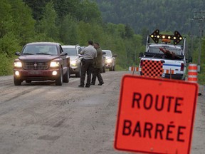 Quebec's forest fire prevention agency is maintaining a high alert for the rest of this week and says the weather conditions are cause for concern. Quebec provincial police check on forest firefighters as they drive out of the territory closed for the night in La Tuque, Que., Monday, May 31, 2010.