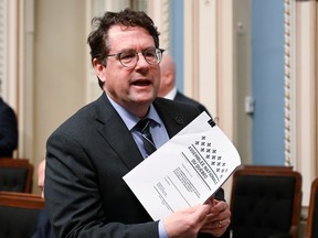 Quebec Education Minister Bernard Drainville holds a copy of education-reform legislation he tabled May 4, 2023.