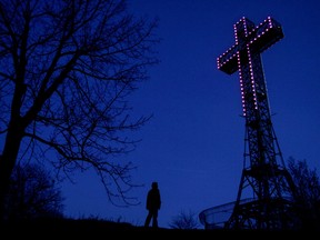 The Mount Royal cross with purple lights at night