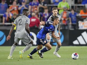 FC Cincinnati forward Yuya Kubo, centre, dribbles against CF Montréal's Victor Wanyama (2) and Gabriele Corbo during the second half of an MLS soccer match on May 17, 2023, in Cincinnati.