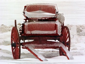 A red carriage sits covered in ice
