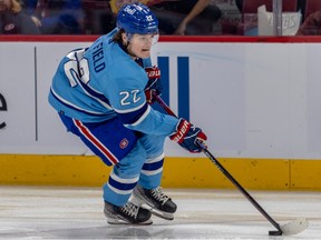 Cole Caufield skates with the puck in a light-blue Reverse Retro jersey
