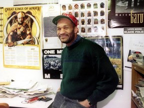 Egbert Gaye smiling, in a community newspaper office