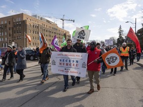 A group of people walk in support of keeping the Lachine Hospital emergency room open in front of the Lachine Hospital in Lachine on March 18, 2023.