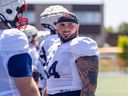 Centre Justin Lawrence on the sideline with fellow offensive lineman during Alouettes training camp in Trois-Rivières last month.
