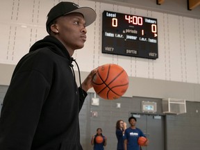 Bennedict Mathurin with a basketball in a high school gym