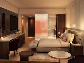 interior of a hotel room with bed, desk and rose-glass bathroom door