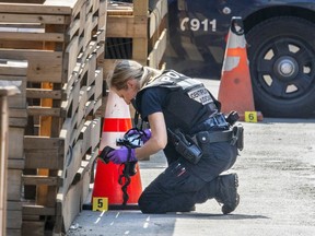 Montreal Police photographer makes photos of a shell casing on the scene of a shooting on Crescent St. in Montreal June 2, 2023.