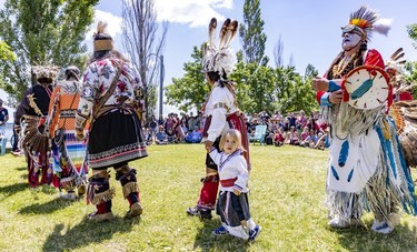 A child is led to a dance during an Indigenous celebration in Montreal