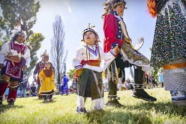 A child is led to a dance during an Indigenous celebration in Montreal