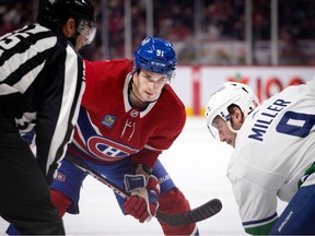 Canadiens' Sean Monahan faces off against Canucks' J.T. Miller.