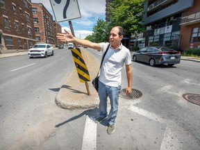 Sonny Moroz stands next to a sign in the middle of a large intersection