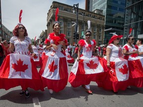 Participants in 2016's Canada Day parade in Montreal walk along Ste-Catherine St.
