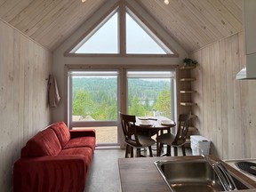 the interior of a scandik chalet with large windows and red sofa