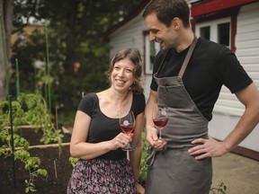 a smiling couple outdoors holding wine glasses