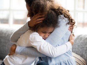 Black mother embraces a sad young child