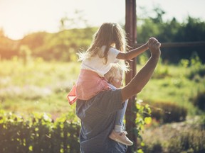 a grandfather carries his granddaughter on his shoulders
