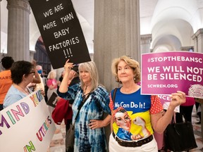 Abortion-rights activists wait for state lawmakers to arrive before a Senate vote on a ban on abortion