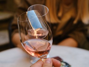glasses of rose wine in the hands of a woman and man