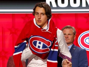 A player puts on a Canadiens jersey on stage at the NHL Draft