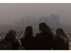 Passengers on the Staten Island Ferry look out over Lower Manhattan as it is shrouded in smoke from Canada wildfires in New York, US, on Wednesday, June 7, 2023. The US Northeast, including New York City, will continue to breathe in choking smoke from fires across eastern Canada for the next few days, raising health alarms across impacted areas.