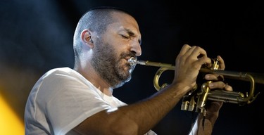 A man plays the trumpet on stage