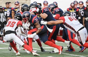 A Montreal Alouettes running back breaks through the Ottawa Redblacks offensive line