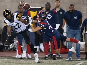 Alouettes wide receiver Trevon Clark (71) misses a pass while covered by Hamilton Tiger-Cats defensive back Will Sunderland (22) during second half CFL pre-season football action in Montreal on Friday, June 2, 2023.