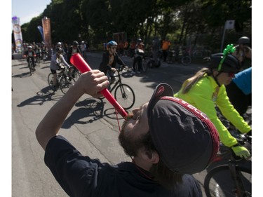A man encourages cyclists on Rosemont Blvd. during the 38th Tour de l'île de Montréal in Montreal on Sunday, June 4, 2023.